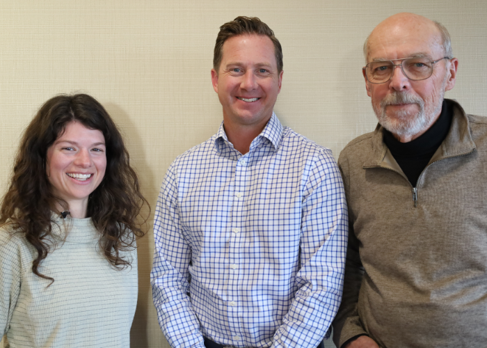 Brynn (left), Matt (center), and Randy (right) stand together in front of a light tan background.